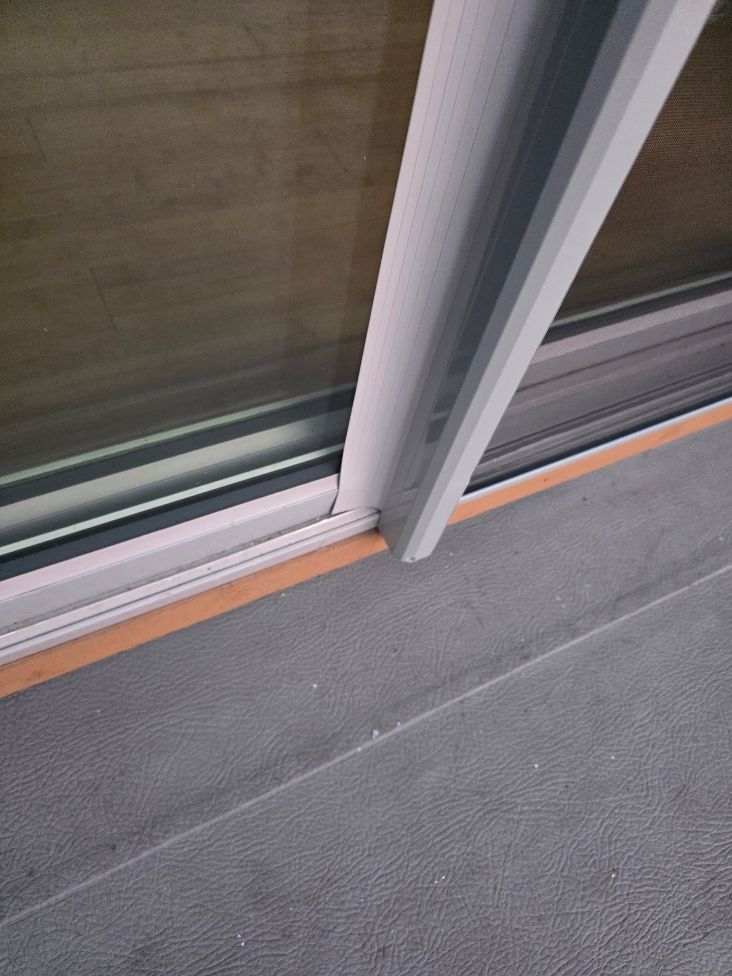 Retractable screen bottom track on flush threshold